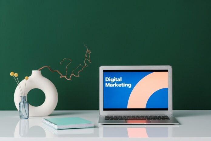 Como fazer consultoria de marketing digital: vasos, um caderno e um notebook cuja tela está escrito 