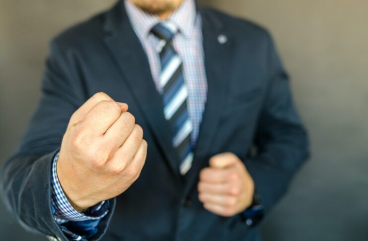 Como usar planos de ação 5W2H na consultoria: homem vestido com terno e gravata em posição de ação